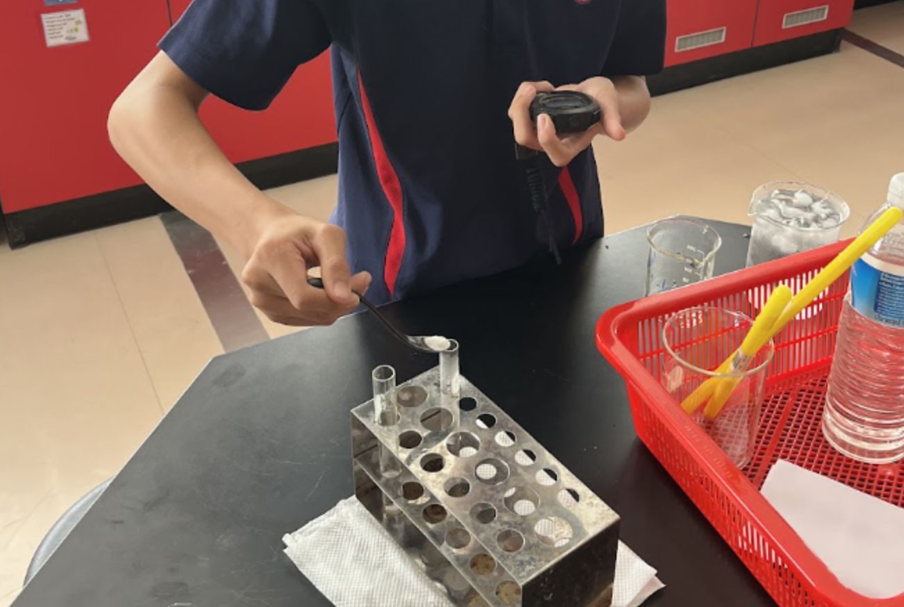 A student measuring out a chemical for a practical lesson